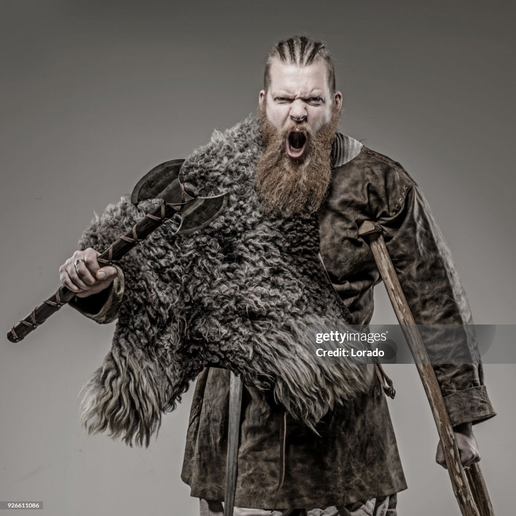 Weapon wielding viking warrior king alone in studio shoot
