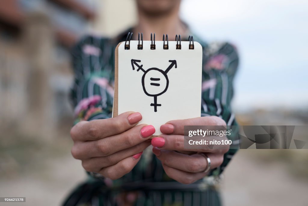 Woman shows notepad with a transgender symbol