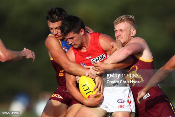 Nic Newman of the Swans is tackled by Hugh McCluggage of the Lions during the AFL JLT Community Series match between the Brisbane Lions and the...