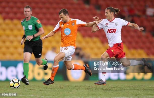 Brett Holman of the Brisbane Roar gets past Michael Marrone of Adelaide United during the round 22 A-League match between the Brisbane Roar and...