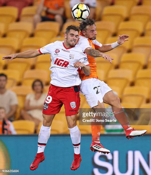 Benjamin Garuccio of Adelaide United and Eric Bautheac of the Brisbane Roar compete for the ball during the round 22 A-League match between the...