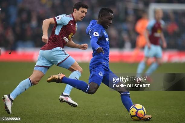 Everton's Senegalese midfielder Idrissa Gueye plays a pass as Burnley's English midfielder Jack Cork looks on during the English Premier League...