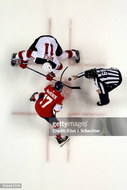 Linesmen Scott Driscoll drops the puck for a face off between Derek MacKenzie of the Florida Panthers and Brian Boyle of the New Jersey Devils at the...