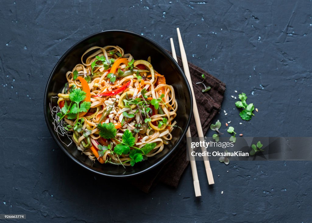 Pad Thai vegetarian vegetables udon noodles in a dark background, top view. Vegetarian food in asian style. Copy space