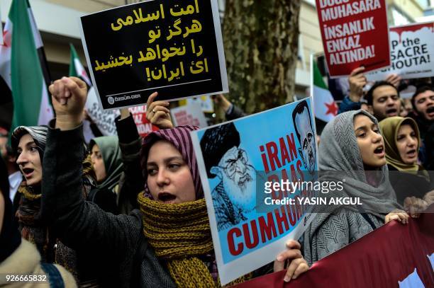 Protesters chant slogans as they hold placards and wave former Syrian 'independence flags' in front of the Iranian Consulate in Istanbul on March 3...