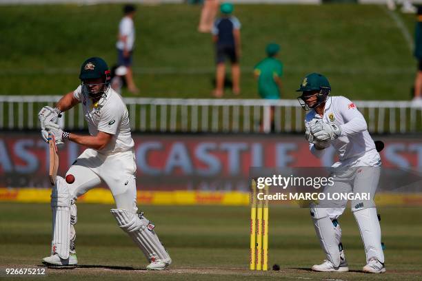 Australian batsman Shaun Marsh is watched by South African wicketkeeper Quinton de Kock as he plays a shot during the third day of the first Test...