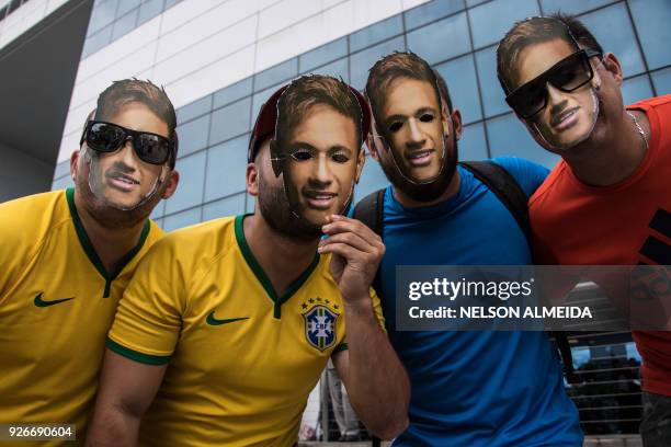 Fans wear a mask of Brazil's forward Neymar, in front of Mater Dei Santo Agostino hospital where he was operated today, in Belo Horizonte, state of...