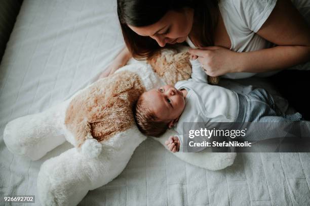 junge mutter hält ihr neugeborenes baby boy - new mum stock-fotos und bilder