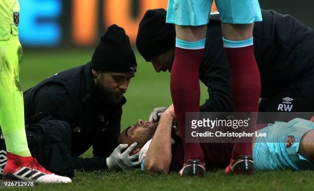 Winston Reid of West Ham United receives treatment following injury during the Premier League match between Swansea City and West Ham United at...