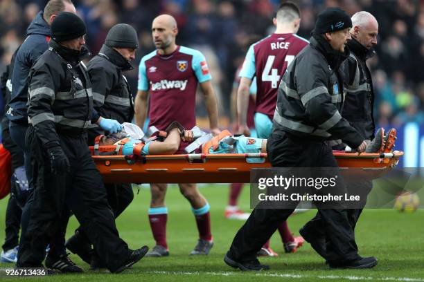 Winston Reid of West Ham United is taken off the pitch on a stretcher during the Premier League match between Swansea City and West Ham United at...