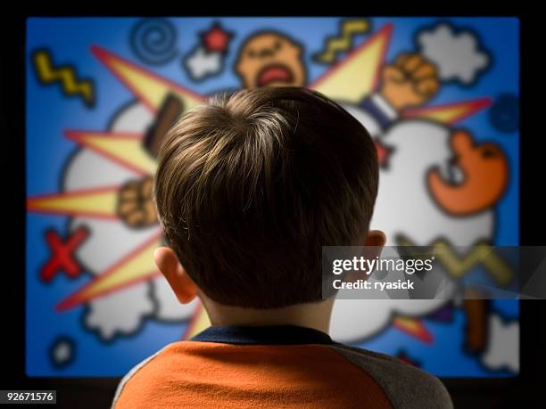 child from behind watching violent cartoon on television - children violence stock pictures, royalty-free photos & images