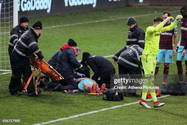 West Ham medical staff see to Winston Reid of West Ham who is injurd on the ground during the Premier League match between Swansea City and West Ham...