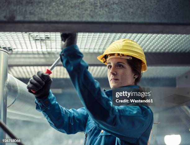 craftswoman wearing hard hat at work - casco protector fotografías e imágenes de stock