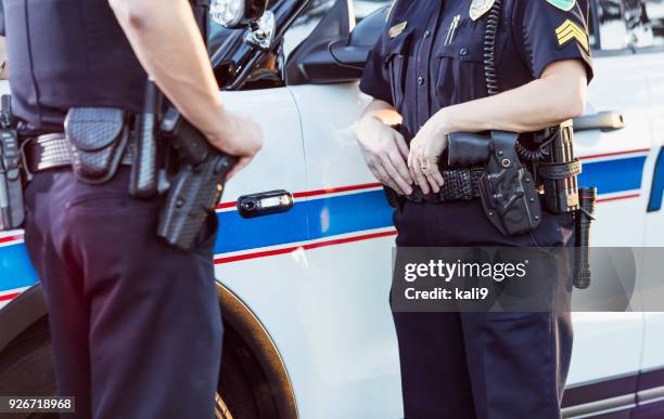 policewoman and partner next to squad car - assembly belt stock pictures, royalty-free photos & images