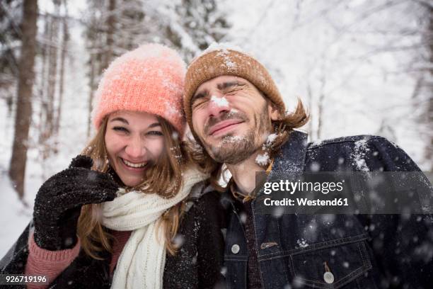 happy couple having fun with snow in winter landscape - couple winter stock pictures, royalty-free photos & images