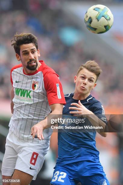 Rani Khedira of Augsburg and Dennis Geiger of Hoffenheim compete for the ball during the Bundesliga match between FC Augsburg and TSG 1899 Hoffenheim...