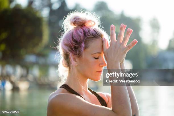 woman with dyed hair meditating at a lake - quiet gesture stock pictures, royalty-free photos & images