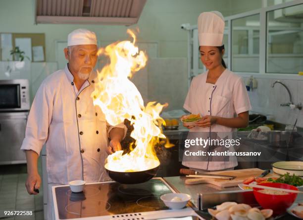 brand- en wok in aziatische keuken - wok stockfoto's en -beelden