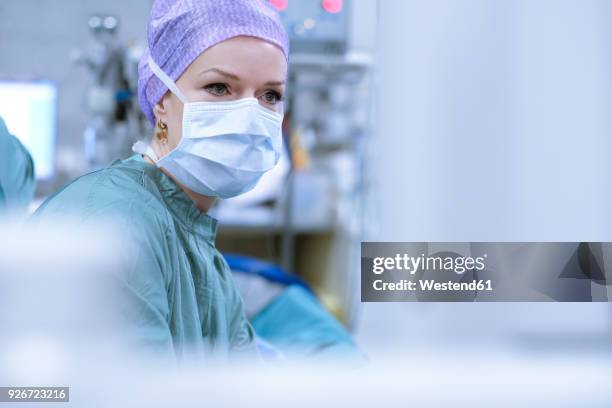 surgeon in scrubs during an operation - ropa de operar fotografías e imágenes de stock