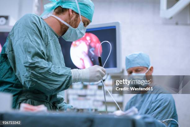 surgical nurse at work during an operation - laparoscopic surgery ストックフォトと画像