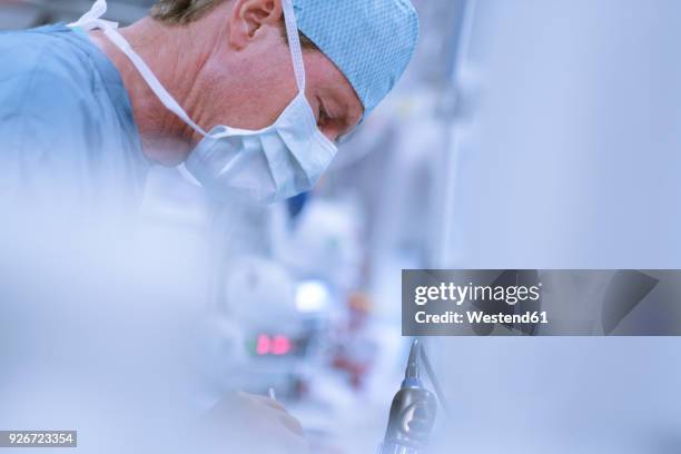 neurosurgeon in scrubs looking down - operating gown stock pictures, royalty-free photos & images