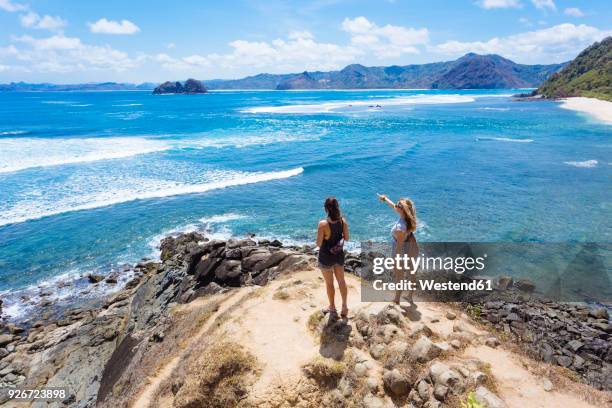 indonesia, lombok, two young women at ocean coastline - lombok bildbanksfoton och bilder