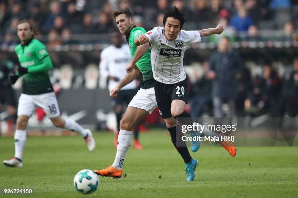 Niclas Fuellkrug of Hannover faiths for the ball with Makoto Hasebe of Frankfurt during the Bundesliga match between Eintracht Frankfurt and Hannover...