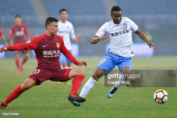 John Obi Mikel of Tianjin Teda and Hernanes of Hebei China Fortune compete for the ball during the 2018 Chinese Football Association Super League...