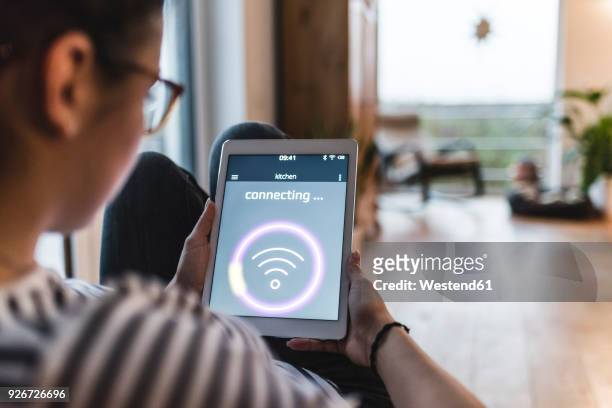 woman using tablet with wifi symbol at home - tecnologia mobile foto e immagini stock