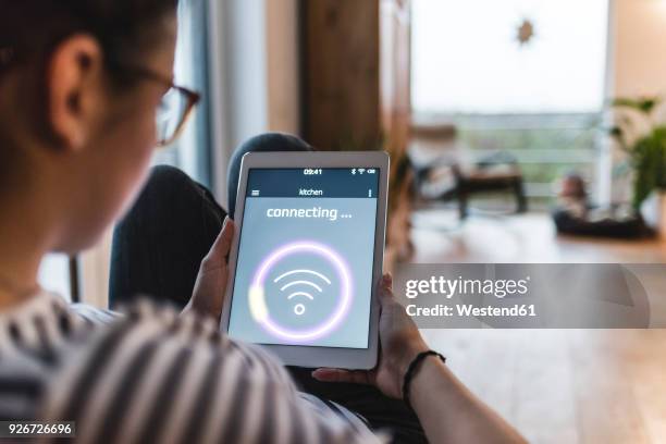 woman using tablet with wifi symbol at home - trådlös teknologi bildbanksfoton och bilder