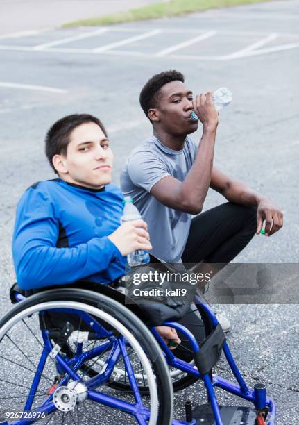 Young amputee and friend, athletes taking break