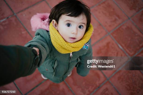 portrait of little girl holding mother's hand looking up - child and unusual angle stockfoto's en -beelden