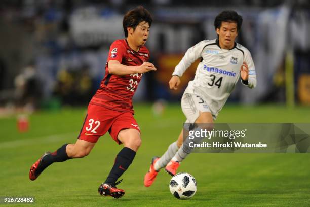 Koki Anzai of Kashima Antlers and Yuya Fukuda of Gamba Osaka compete for the ball during the J.League J1 match between Kashima Antlers and Gamba...