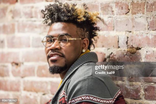 face of young mixed race man leaning on brick wall - handsome native american men stock pictures, royalty-free photos & images