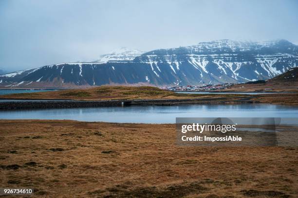 landscape of snowcapped mountain and the village nearby in winter at iceland. - impossiable fotografías e imágenes de stock