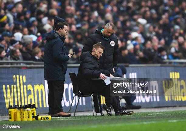 Injured referee Mike Jones is given assistance as he operates as fourth official during the Premier League match between Tottenham Hotspur and...