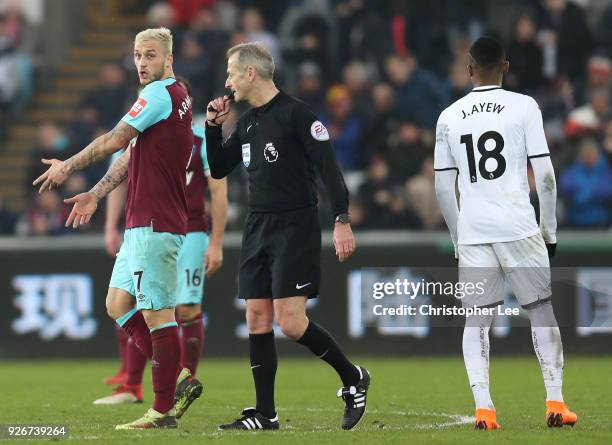 Marko Arnautovic of West Ham United confronts referee Martin Atkinson during the Premier League match between Swansea City and West Ham United at...