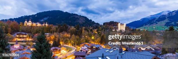 switzerland, canton of bern, gstaad, townscape with gstaad palace hotel at dusk - gstaad stockfoto's en -beelden