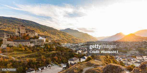 switzerland, canton vaud, sion, townscape with notre-dame de valere at sunset - rhone stockfoto's en -beelden