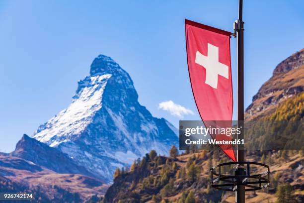 switzerland, valais, zermatt, matterhorn, swiss flagg - switzerland snow stock pictures, royalty-free photos & images