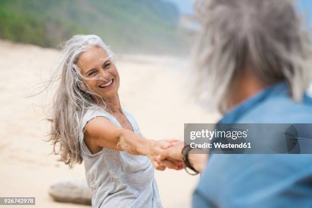 handsome senior couple dancing on the beach - westend61 fotografías e imágenes de stock