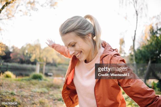 portrait of happy young woman balancing in autumnal park - beauty balance stockfoto's en -beelden