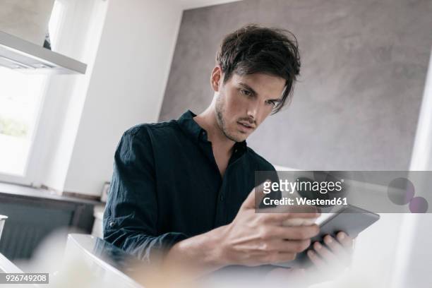 portrait of young man using tablet for getting information of a product - man glasses tablet in kitchen stock pictures, royalty-free photos & images
