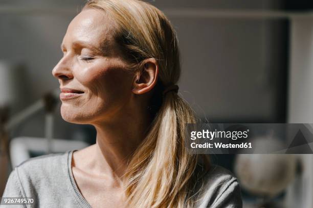 portrait of smiling woman's face in sunlight - menschliches gesicht stock-fotos und bilder