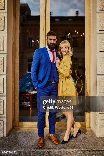 portrait of elegant couple standing at a window - elegant couple stockfoto's en -beelden