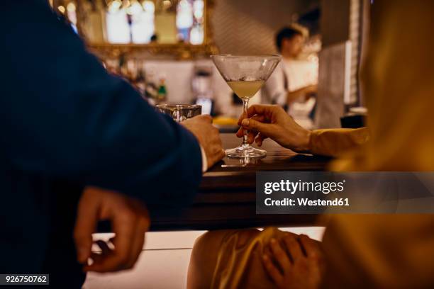 close-up of elegant couple having a drink at the counter in a bar - first date stockfoto's en -beelden