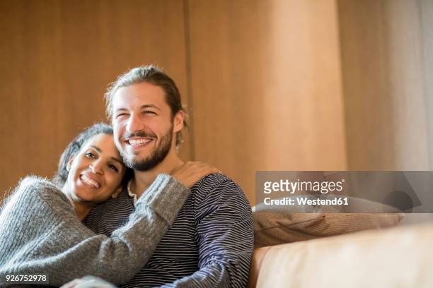 portrait of happy young couple sitting on the couch - head on shoulder stock pictures, royalty-free photos & images