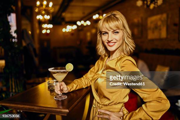 portrait of elegant woman with cocktail in a bar - cocktail dress bildbanksfoton och bilder