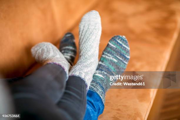 feet of couple in love lying on couch - stocking feet fotografías e imágenes de stock