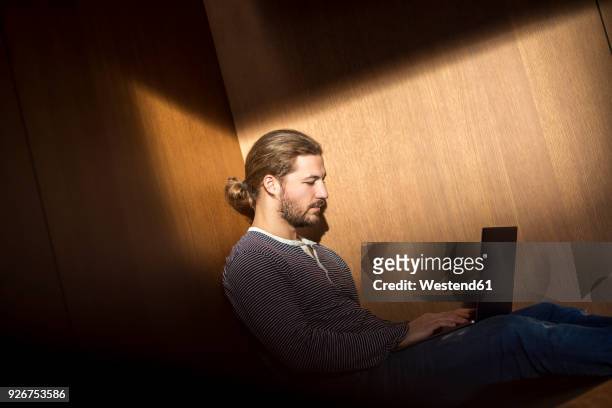 portrait of young man using laptop - kontrastreich stock-fotos und bilder